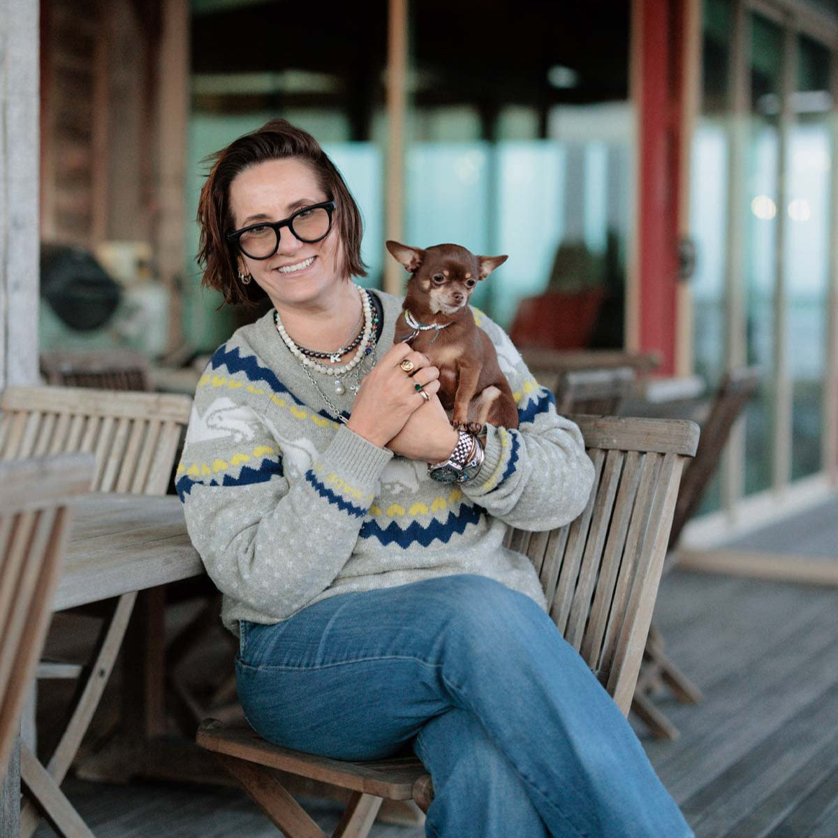 Woman holding a small dog in an outdoor setting